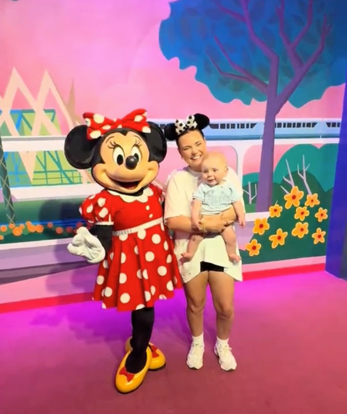 Mom and baby posed with Minnie Mouse