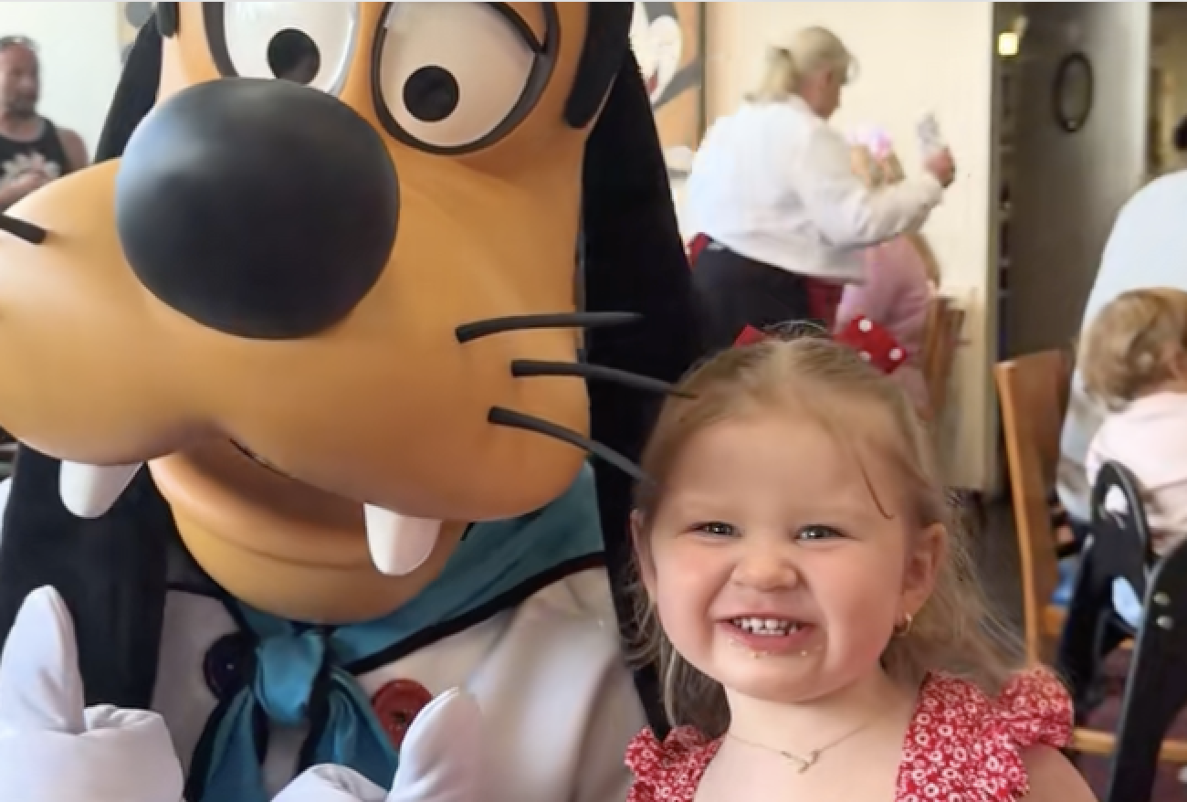 little girl posed with goofy