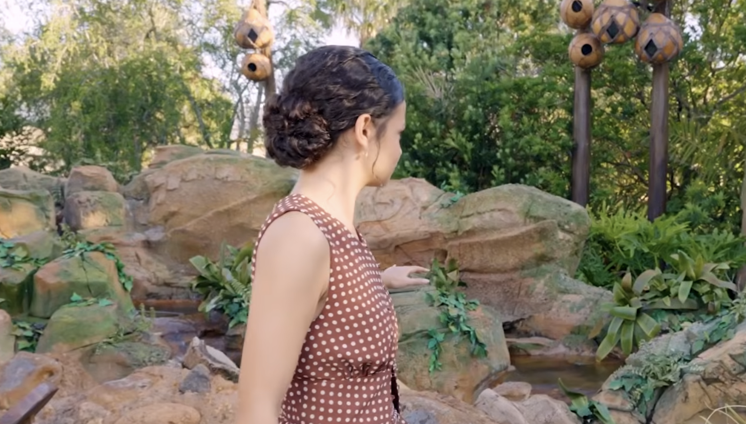Catherine Laga'aia stands in front of a large topiary shaped like Te Fiti from Disney’s Moana.