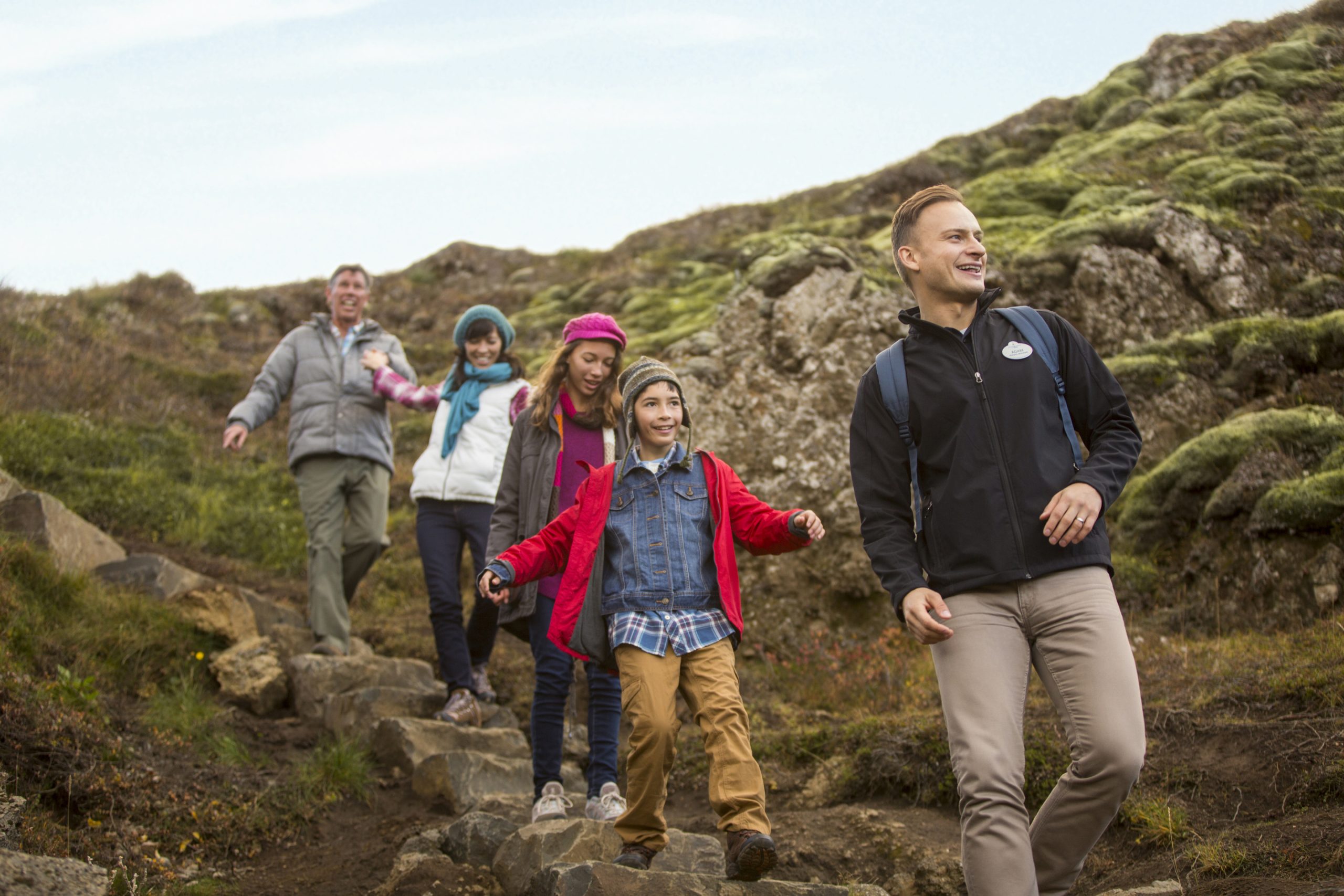 An Adventure Guide leads a family down a hillside on an Adventures by Disney trip. 