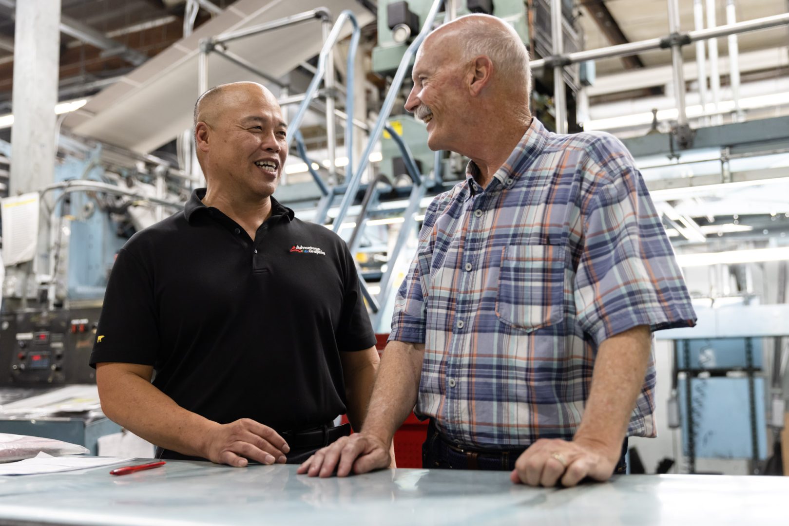 Tom (left) and Les, one of Advantage ColorGraphics’s longest standing employees, share a laugh in the company’s warehouse.