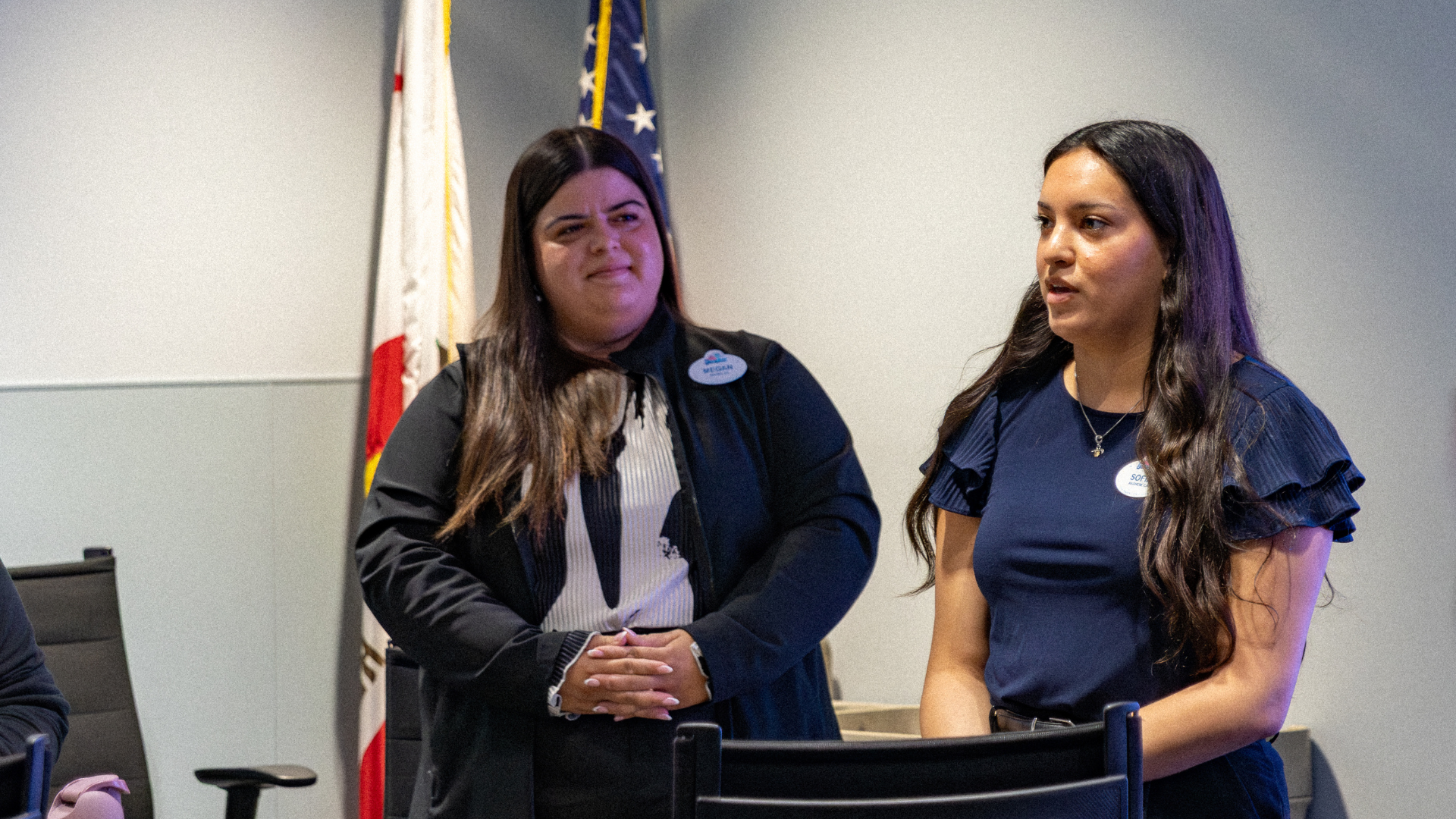 Megan looks over at Sofia and intently listens as she shares her “Toast for Change,” where she spoke words of gratitude for Megan’s guidance and advice throughout the program.